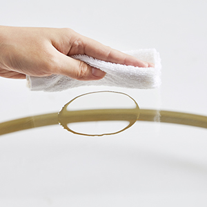 une main tenant un tissu sur un cadre doré.