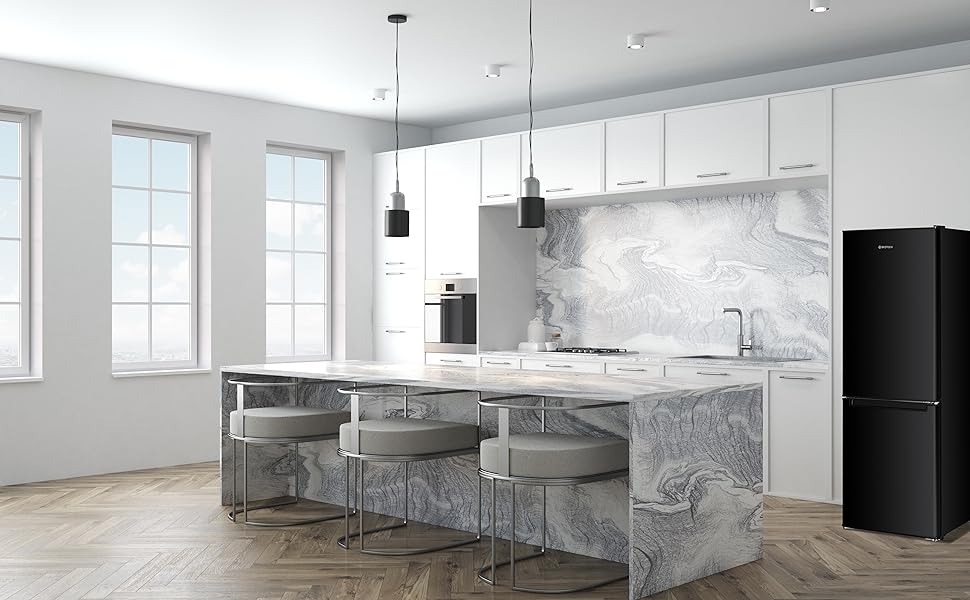 Intérieur de cuisine moderne avec armoires blanches, îlot et dosseret d'aspect marbre, plancher en bois franc à chevrons, lampes suspendues noires et réfrigérateur noir mat