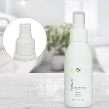 un flacon de produit de soin naturel à côté d'un lit.