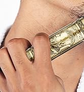 Bague dorée ornée d'un motif en relief orné représentant un visage, portée au doigt contre la peau