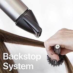 Sèche-cheveux photo près des cheveux au-dessus de la brosse ronde.