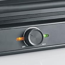 Série rapprochée d'un panneau de commande électronique noir ou d'une interface montrant divers boutons et cadrans sur une surface métallique.