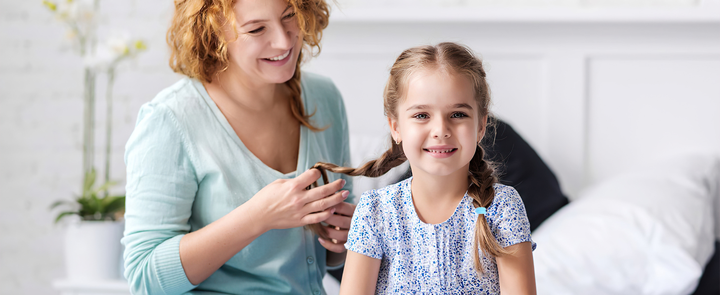 Une femme tressant les cheveux d'une jeune fille dans un cadre domestique. Les deux sourient, ce qui suggère une expérience de coiffure positive