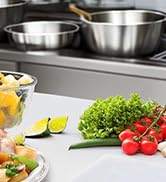 avec bols à mélanger en acier inoxydable, légumes frais, y compris les tomates et la laitue, et agrumes. Ingrédients affichés pour la préparation des aliments.