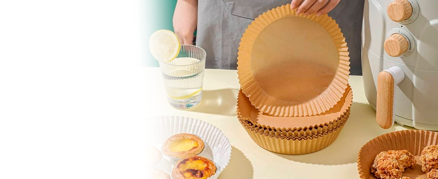 Pile de grands moules à pâtisserie en papier cannelé de couleurs orange et blanc, disposés sur une table avec des produits de boulangerie à proximité
