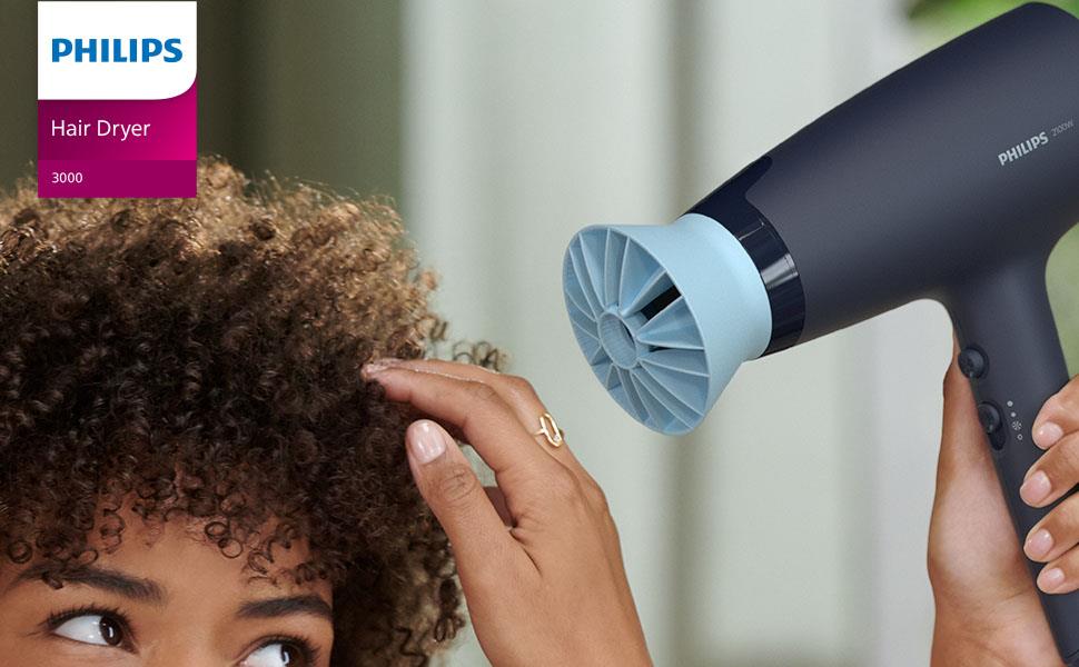 Femme utilisant le sèche-cheveux Philips série 3000