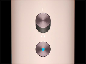 Deux boutons ou commandes circulaires métalliques sur fond beige, l'un semble lisse et l'autre possède une surface réfléchissante bleue.