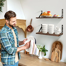 un homme debout dans une cuisine tenant un torchon.