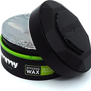 Récipient à cire à coiffer circulaire noir avec accent vert. Couvercle ouvert montrant le produit blanc à l'intérieur. L'étiquette indique « Coiffing Wax » avec « Mat Finish »