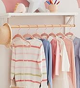 Porte-vêtements en bois avec chandails et chemises aux couleurs pastel suspendus. Comprend un chapeau et des objets de décoration sur l'étagère ci-dessus.