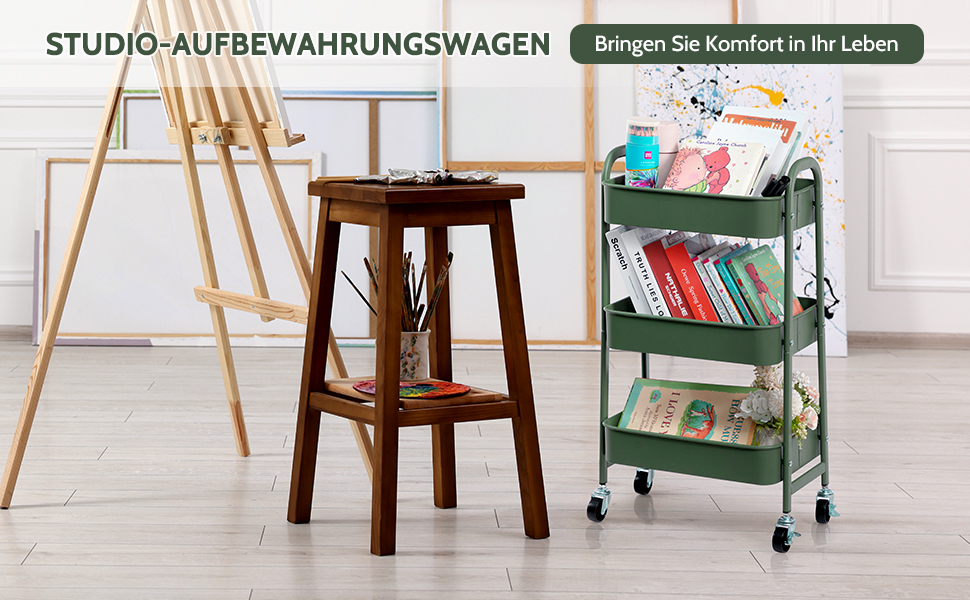 Chariot utilitaire en métal vert à trois niveaux sur roues, rempli de livres et de fournitures artistiques. Tabouret en bois et chevalet à proximité dans un décor de studio d'art