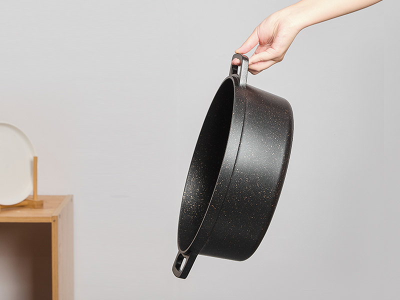 Séquence montrant un objet circulaire noir soulevé et manipulé sur un fond blanc minimal orné de touches de bois.