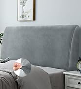 Un canapé gris avec la main d'une personne tenant une télécommande, la pointant vers un appareil mural, probablement pour contrôler la température ou l'éclairage de la pièce