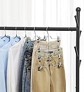 Porte-vêtements noir avec divers vêtements suspendus à l'aide de cintres et de clips. Les articles visibles incluent des chemises bleu clair, des chemises blanches, des jeans et des pantalons kaki