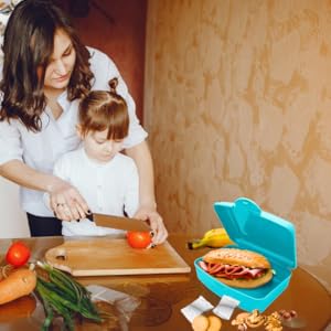 Maman prépare la boîte à lunch pour que sa fille l'emmène à l'école