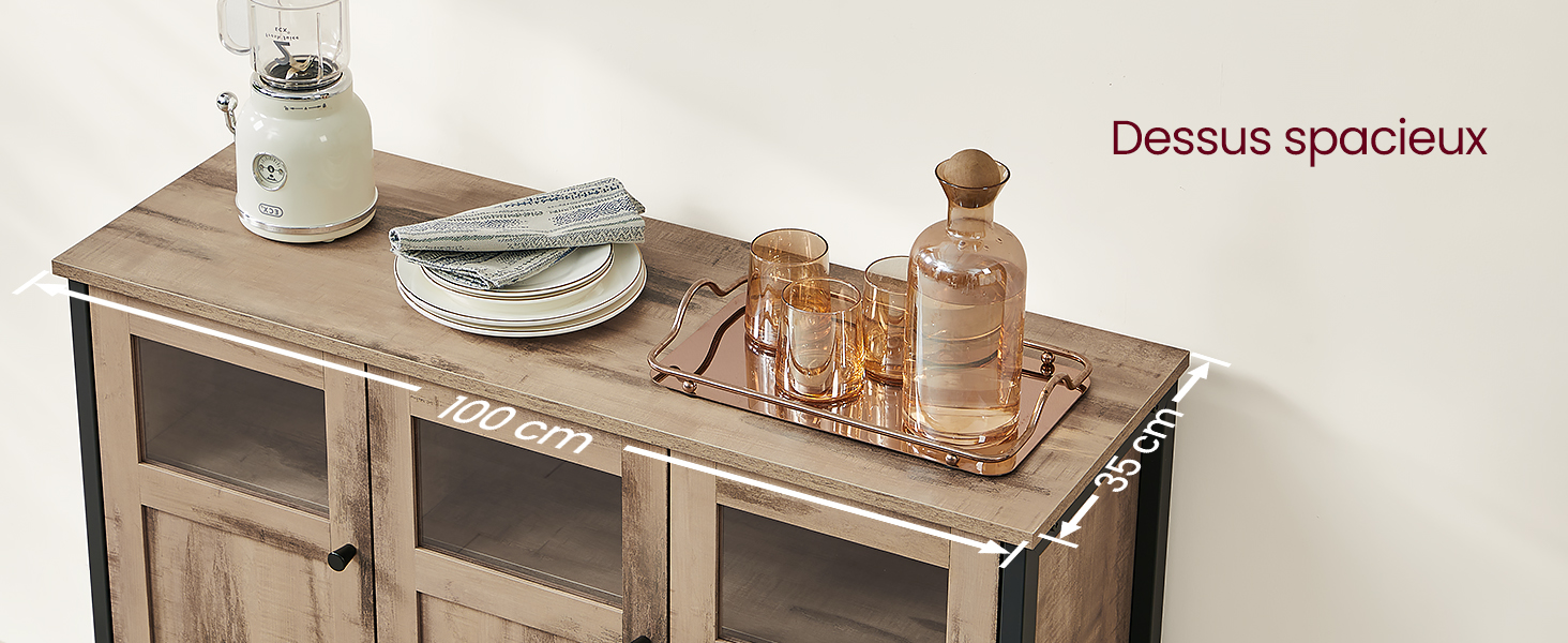 avec portes vitrées et plateau spacieux. Décoré avec des assiettes, des verres et une cruche en céramique blanche. Texte « Dessus spacieux » visible.