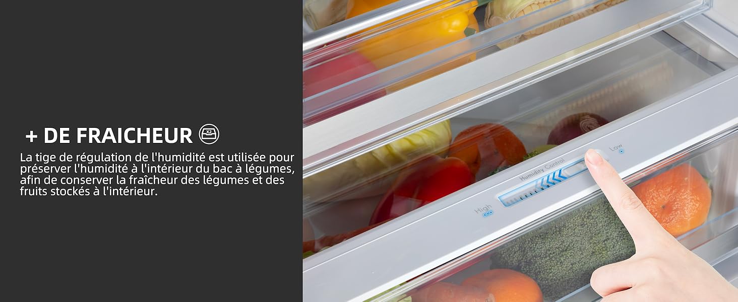 Le tiroir du réfrigérateur est ouvert et présente divers produits frais, notamment des tomates, des carottes et d'autres légumes. Main tendue dans le tiroir.