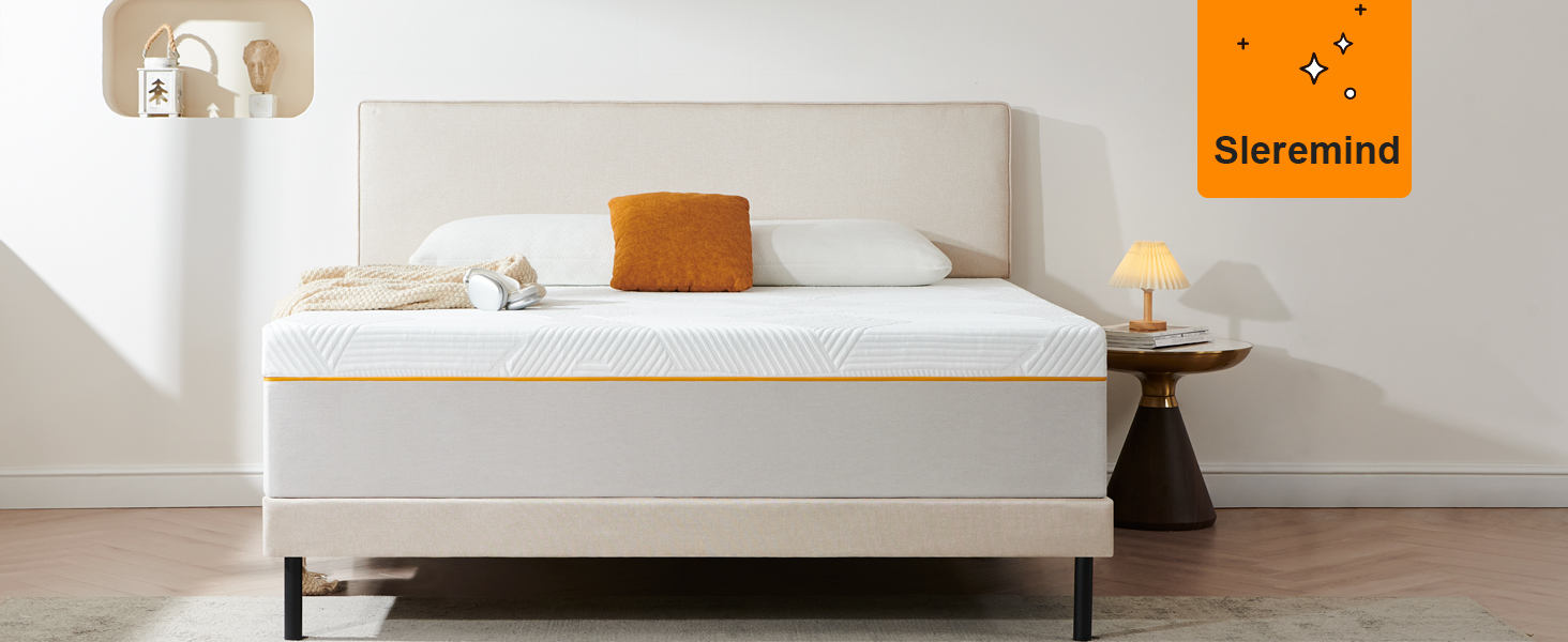 Chambre minimaliste dotée d'un cadre de lit rembourré beige et d'un matelas blanc. Coussin décoratif orange sur literie blanche. Table d'appoint en bois avec petite lampe.