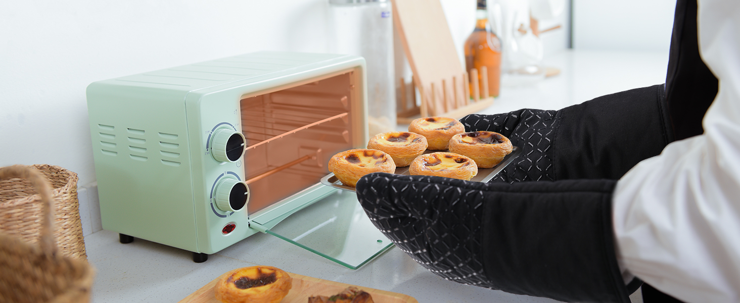 vert menthe sur un comptoir de cuisine, avec des pâtisseries fraîchement sorties du four visibles. Les jambes d'une personne vêtue d'un pantalon noir sont visibles à proximité.
