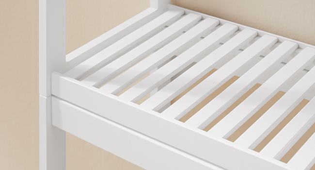 Vue rapprochée de lattes de lit en bois blanc disposées parallèlement dans un cadre, montrant la construction de meubles de chambre à coucher offrant un soutien