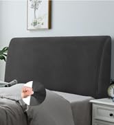 Tête de lit rembourrée grise présentée dans le décor de la chambre à coucher avec table de chevet blanche et décoration murale