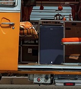 une camionnette avec un lit et une glacière à l'intérieur.