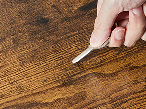 une main tenant une fourchette sur une table en bois.