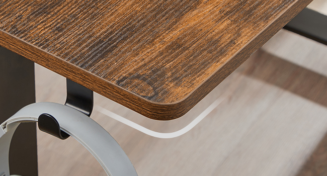 Coin d'un plateau de table en bois aux bords arrondis, présentant une finition lisse teintée foncée. Un cadre métallique est visible en dessous.