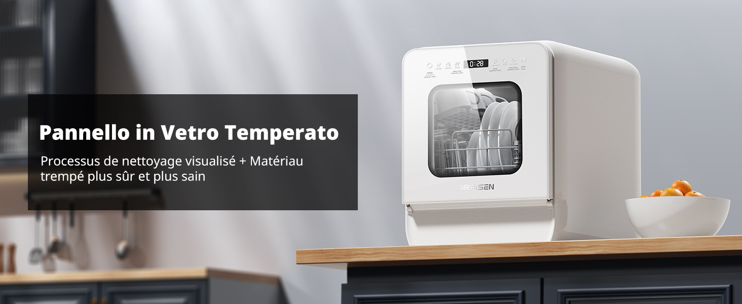 Lave-vaisselle de comptoir compact blanc avec panneau avant en verre, affiché sur un comptoir de cuisine sombre. Support intérieur visible et bras de pulvérisation. Fruits oranges dans un bol à proximité.