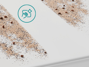Gros plan d'une surface blanche avec de petites taches brunes ou des mouchetures éparpillées sur celle-ci. Une icône ou un symbole circulaire apparaît dans le coin supérieur droit.