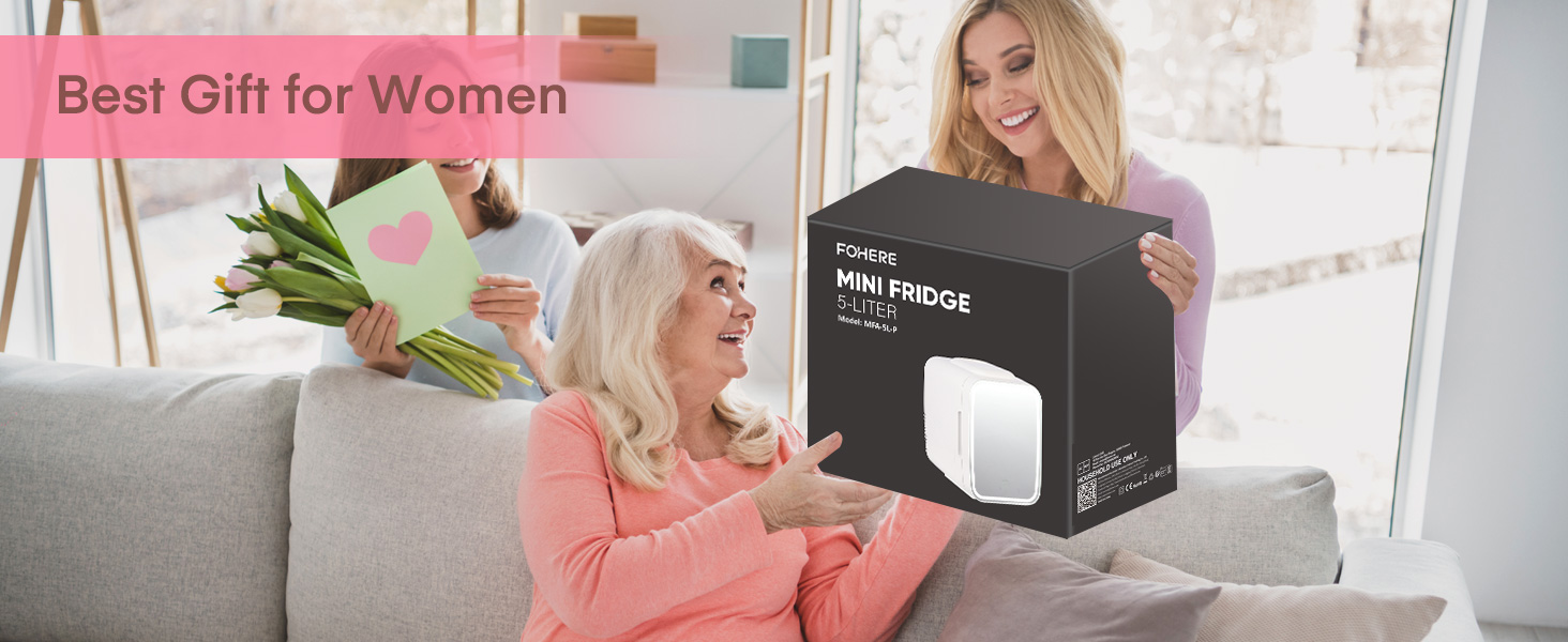 Une femme plus âgée assise sur un canapé reçoit un coffret cadeau intitulé « MINI PROJECTEUR » d'une femme plus jeune. Le texte superposé indique « Meilleur cadeau pour femme