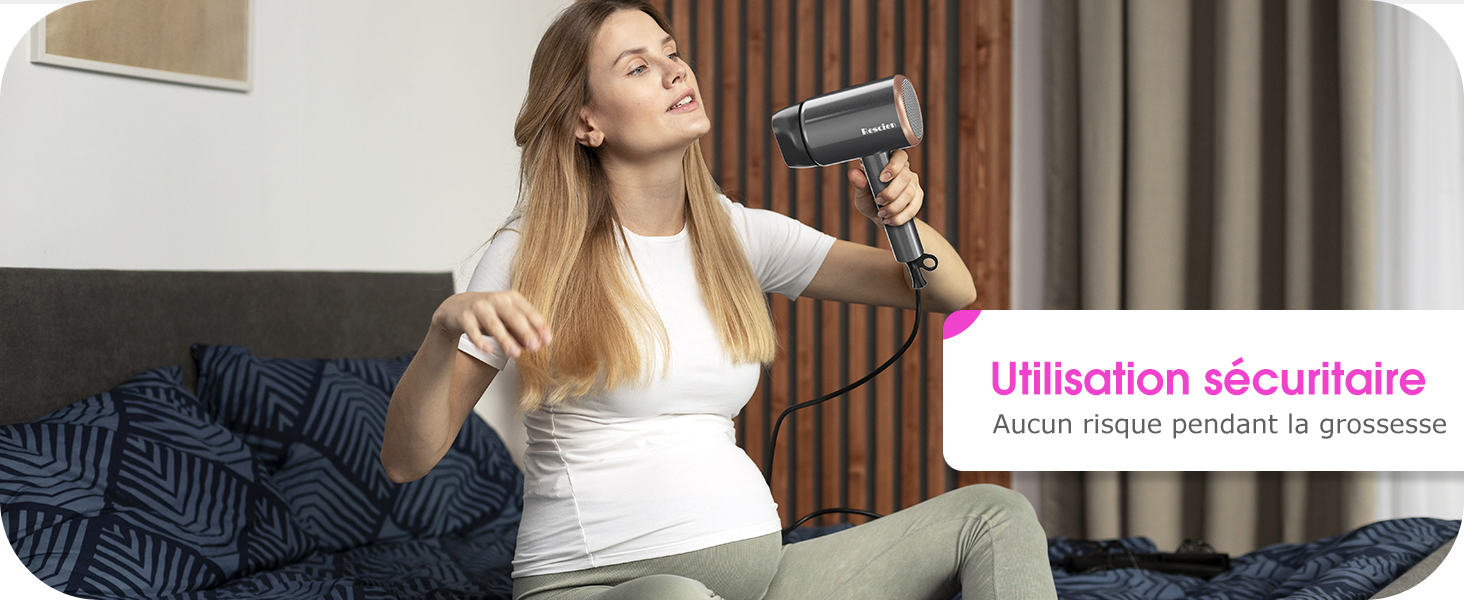 Femme utilisant un sèche-cheveux à main avec une buse arrondie. Le texte en français suggère une utilisation sûre pendant la grossesse. L'appareil semble être un outil de coiffure spécialisé.