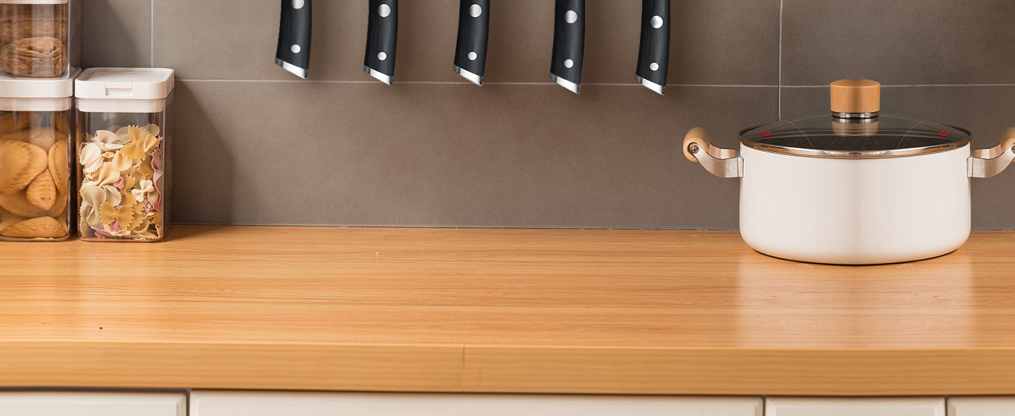 une planche à découper en bois avec des couteaux qui en sortent.