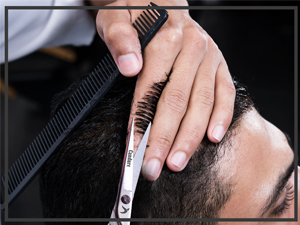 Gros plan des mains à l'aide de ciseaux de coupe de cheveux professionnels sur fond sombre