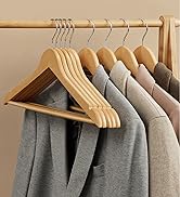 Porte-vêtements en bois avec plusieurs cintres en bois pouvant contenir des vêtements gris, beiges et blancs, avec rangement organisé