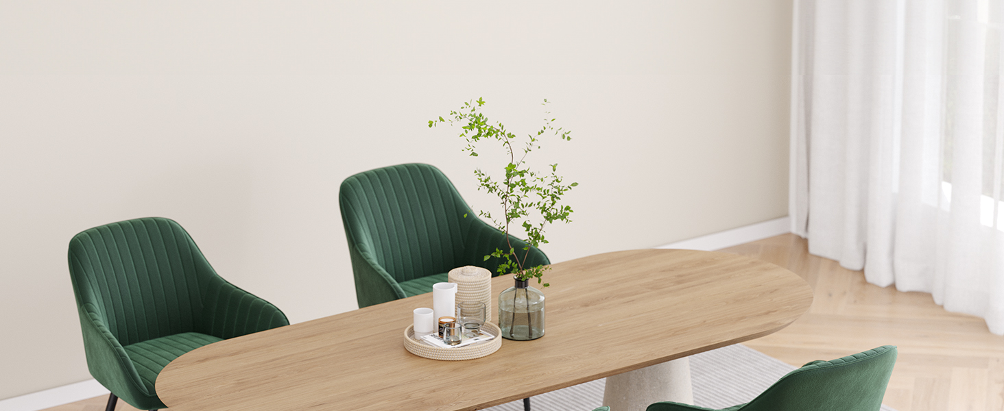 avec table en bois, chaises rembourrées vertes et pièce maîtresse décorative dans une pièce lumineuse aux rideaux blancs