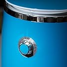 Gros plan d'un cadran circulaire métallique ou d'un bouton de réglage sur une surface bleu vif avec bordure chromée.