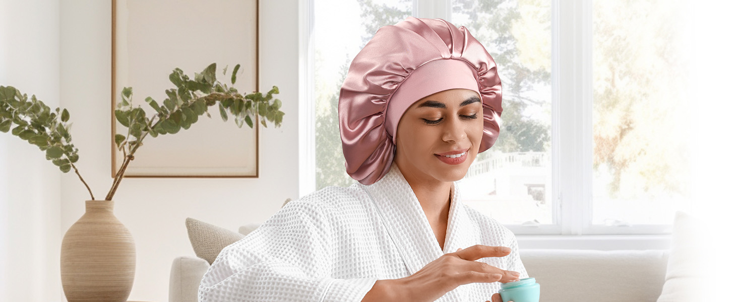 une femme en peignoir rose applique une serviette de bain sur son visage