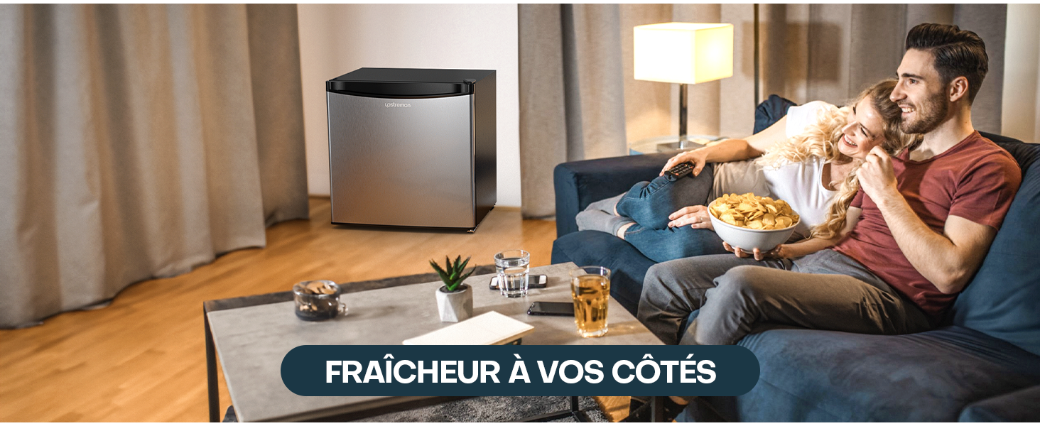 dans le coin du salon. Couple sur le canapé dégustant des collations, démontrant la commodité de la réfrigération à proximité pour les rafraîchissements et le stockage des aliments