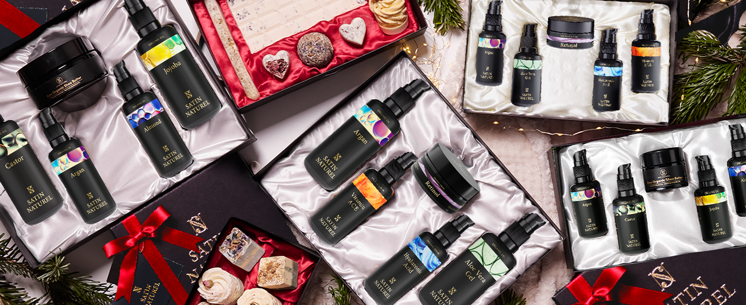 Assortiment de petites bouteilles en verre foncé contenant des huiles essentielles ou des produits d'aromathérapie, présentées avec des coffrets cadeaux et des décorations de Noël sur une surface blanche