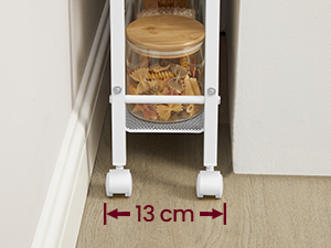 Étagère de rangement étroite entre les meubles, 13 cm de large. Des étagères blanches peuvent contenir des contenants alimentaires. Plancher en bois et murs blancs visibles.