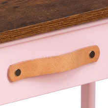 Gros plan d'un détail de meuble montrant une poignée en cuir beige montée sur une surface rose avec un bord supérieur en bois visible