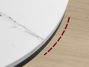 Gros plan d'un coin où deux surfaces se rencontrent : un matériau semblable à du marbre blanc et une surface à grain de bois clair. Une ligne rouge pointillée se courbe le long de l'articulation
