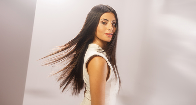 De longs cheveux noirs représentés en mouvement sur un fond clair, démontrant un mouvement fluide et une brillance sous plusieurs angles.