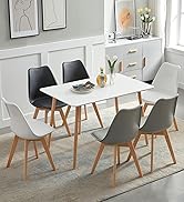 avec table rectangulaire blanche et six chaises en noir, blanc et gris. Pieds en bois sur les chaises et la table. Situé dans une chambre lumineuse décorée.