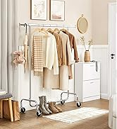 Porte-vêtements en métal à roulettes, présentant divers vêtements dans des tons neutres. Un meuble à tiroirs blanc et des objets de décoration complètent l'espace de rangement organisé.