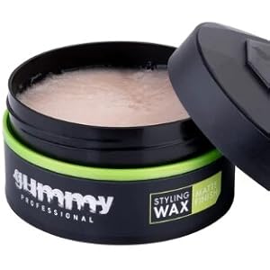 Ouvrez le contenant noir de cire à coiffer avec un accent vert. Le produit a une finition mate et semble être un produit capillaire de qualité professionnelle