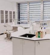 Intérieur de laboratoire moderne avec armoires blanches, plans de travail et évier, avec rangement intégré et espace de travail au design épuré