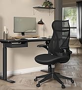 Configuration de bureau à domicile moderne avec chaise ergonomique en maille noire, écran mural, lampe de bureau et bureau debout noir contre un mur beige
