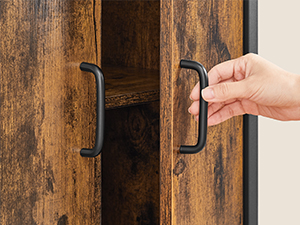 Tendez la main pour saisir une poignée en métal foncé montée sur une porte ou une surface en bois patiné, pour démontrer l'utilisation de la poignée